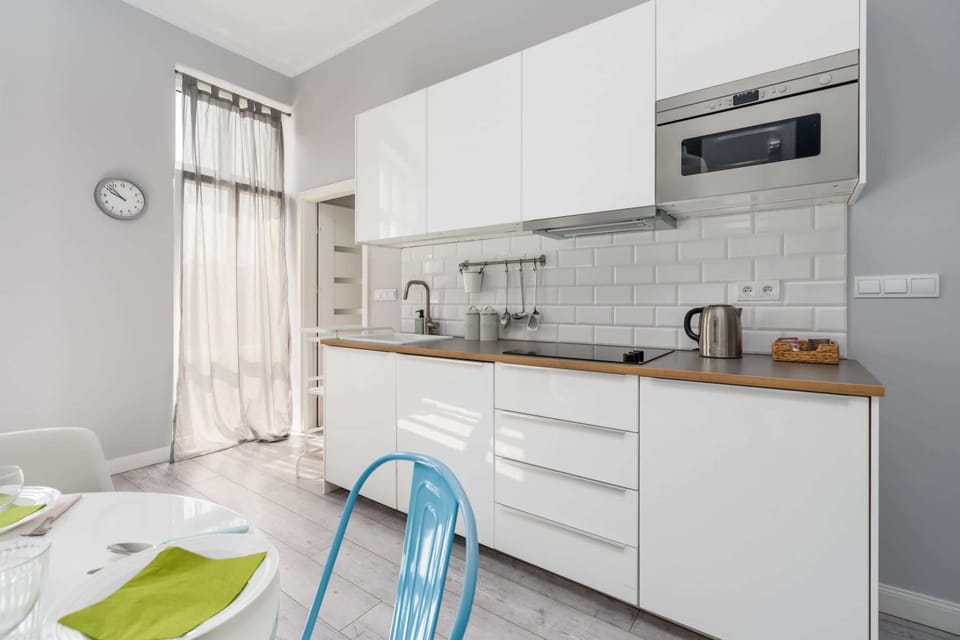 Fully equipped kitchen with sleek white cabinetry, wooden countertops, and ample storage space.

