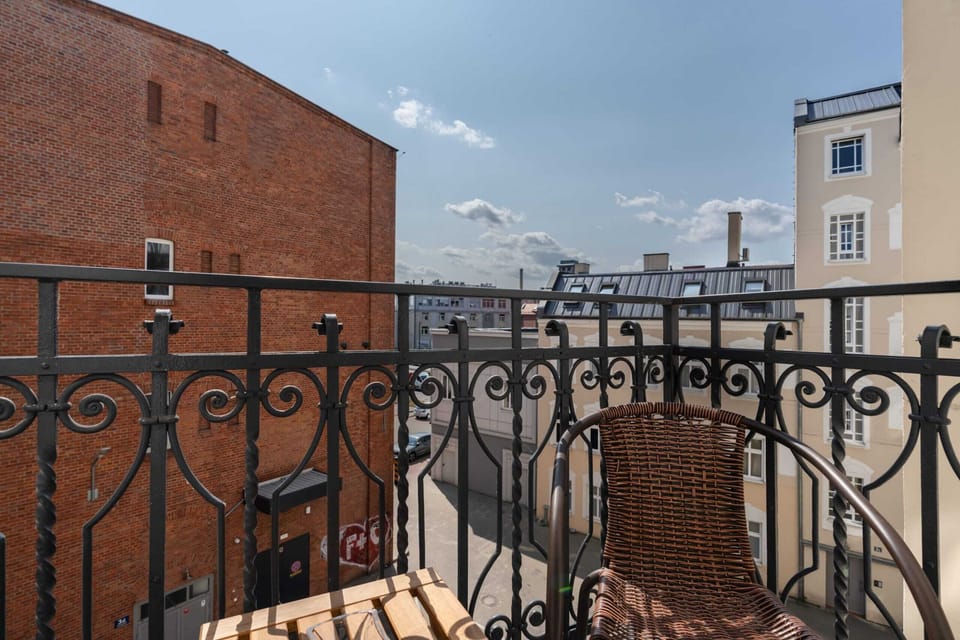 Another perspective of the balcony highlighting its wrought-iron railing and a cozy outdoor seating arrangement.

