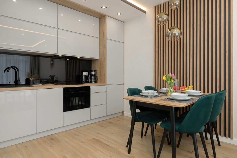 Fully equipped kitchen with white cabinets, black countertops, and built-in appliances.

