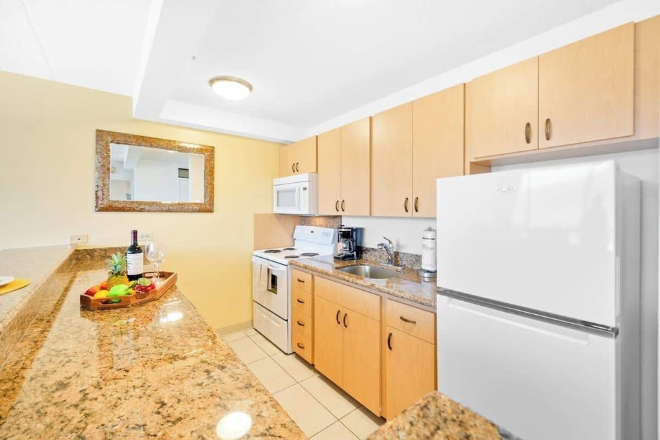 The well-appointed full kitchen features granite countertops, ample wood cabinetry, and all the essential appliances for preparing meals.