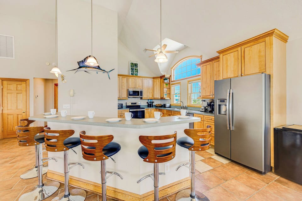 A chef's oasis featuring a sleek breakfast bar and premium stainless steel appliances.