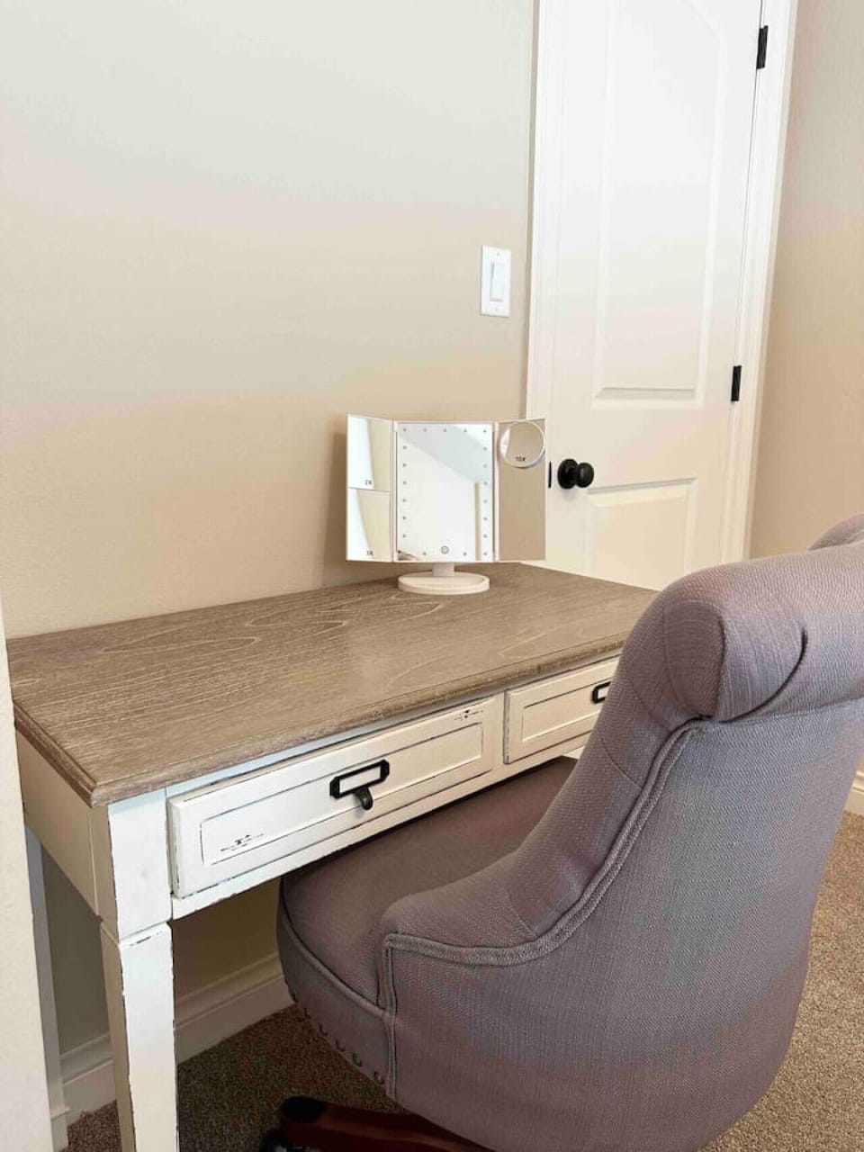 Bedroom workspace with a desk and comfortable chair.