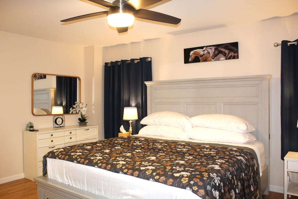 Master bedroom with luxurious king bed, dresser, and attached bathroom & closet