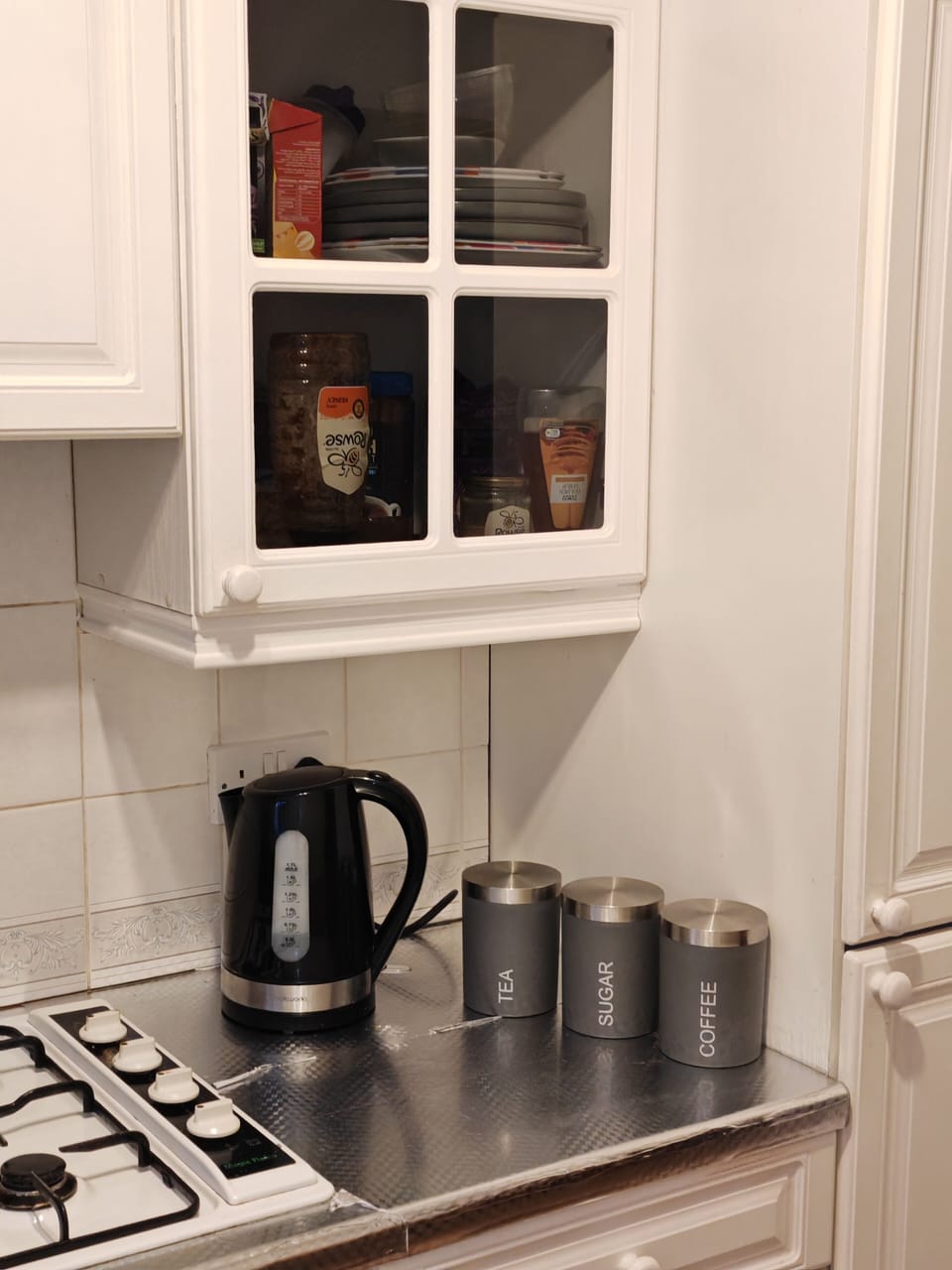 Kitchen with tea, coffee, sugar, oven, hob, microwave, washing machine, cutlery, etc
