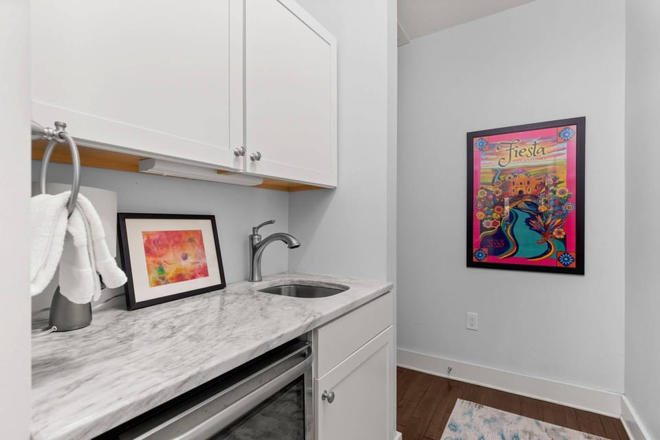 Sophisticated primary bedroom ensuite wet bar, adorned with a wine fridge and elegant marble counters, enhance your stay with a touch of luxury.