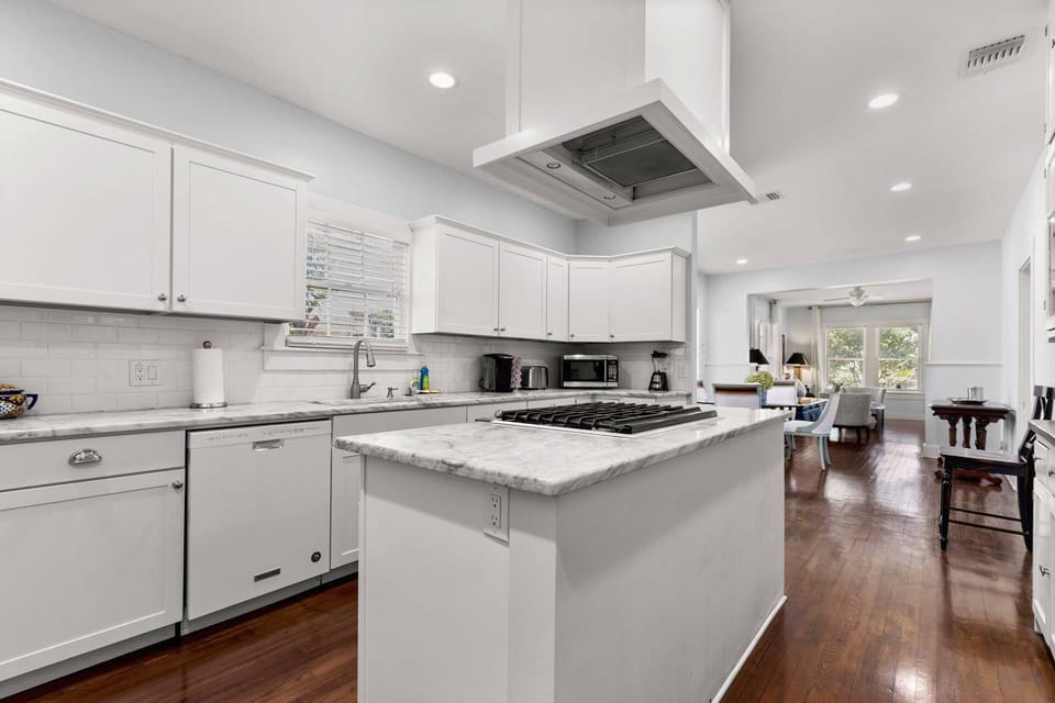 Let culinary inspiration flow in the open kitchen, featuring a cooktop island and a striking grand vent hood that redefine your cooking experience.