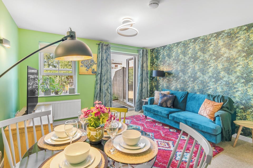 As you step into the dining room, your eyes are immediately drawn to the vibrant centerpiece - a truly captivating and colorful dining table that exudes an air of lively elegance. 