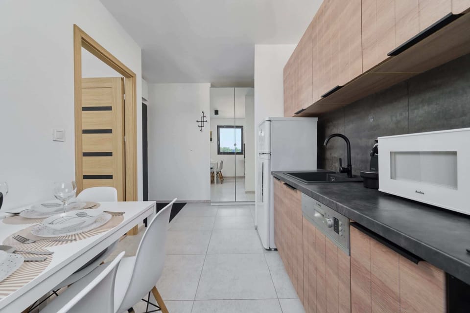 Modern kitchen featuring wooden cabinets, a sleek countertop, and a fully equipped cooking space.

