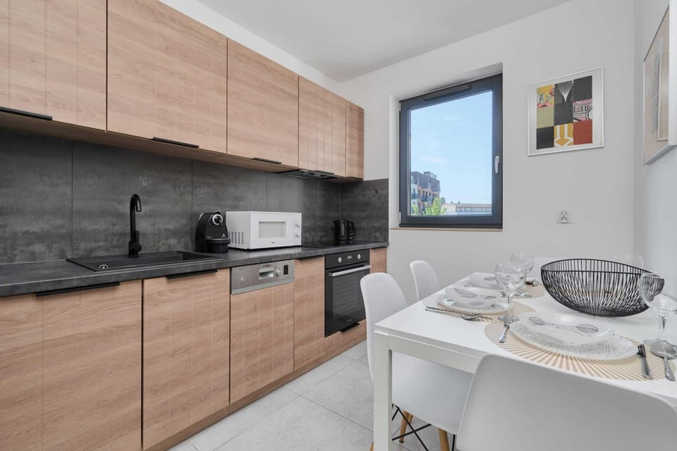 Kitchen with a modern dining table, large windows, and all the necessary appliances for cooking.







