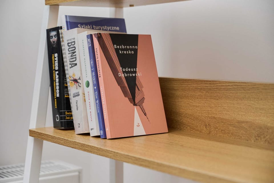 A small bookshelf with books and decor, offering a functional and stylish workspace.

