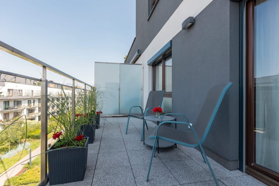 Balcony with outdoor seating and potted plants, providing a peaceful retreat.

