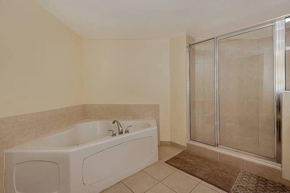 Spacious master bathroom with both a bathtub and a shower, offering flexibility and comfort.