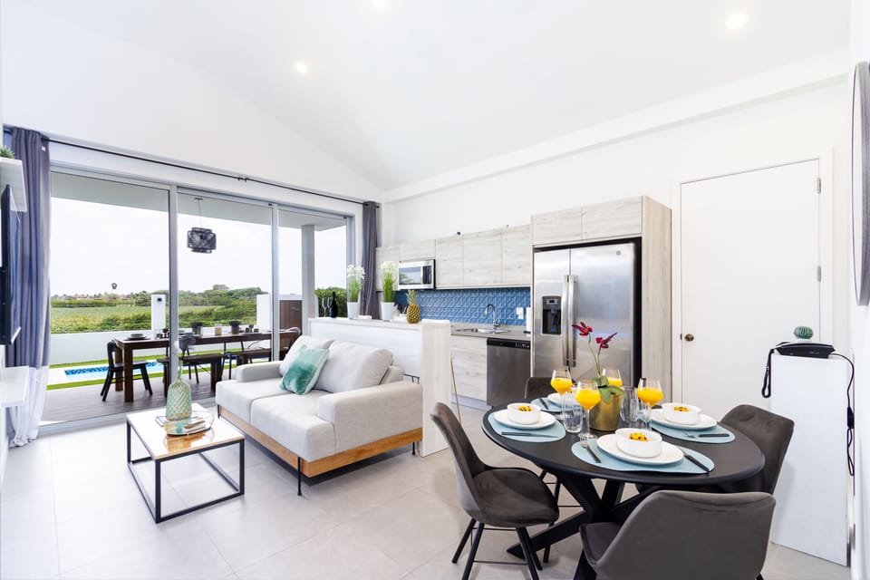 Step into this bright, open-concept space where the living, dining, and kitchen areas blend seamlessly, offering expansive green views beyond your sliding doors.