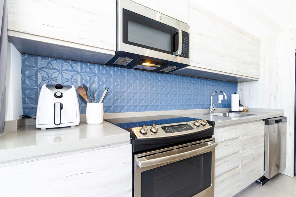 Your modern kitchen features stainless steel appliances, stylish blue geometric backsplash, and everything you need for easy meal prep during your stay.
