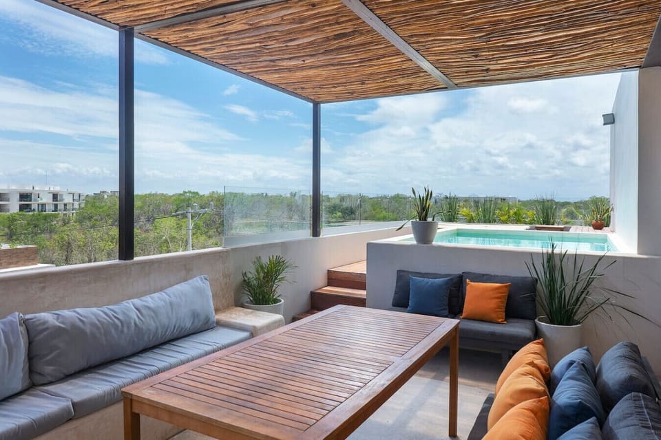 Rooftop dining with comfy seating and extra pillows for lounging.