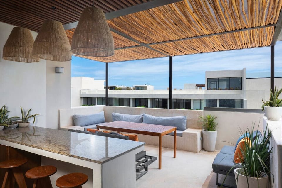 Rooftop with outdoor kitchen, bar, dining area, and private pool.