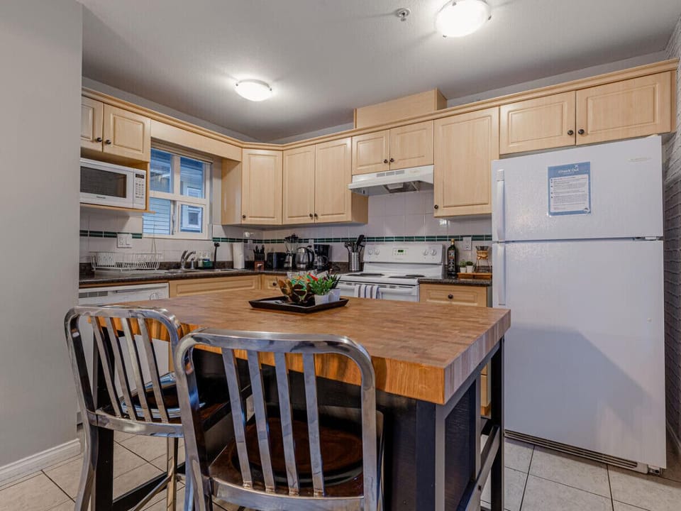 The spacious kitchen island serves as a perfect breakfast spot, offering ample counter space for food prep and casual dining.