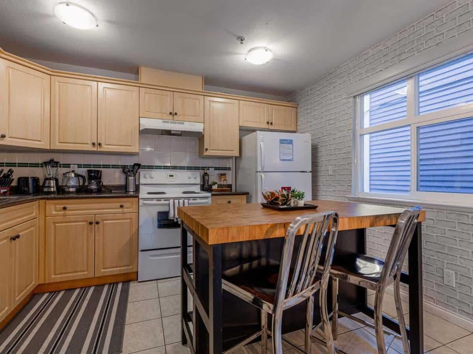 The spacious kitchen island offers a perfect spot to enjoy breakfast or a quick snack. Bright and fully equipped, this inviting space makes dining and meal prep feel effortless and homey.