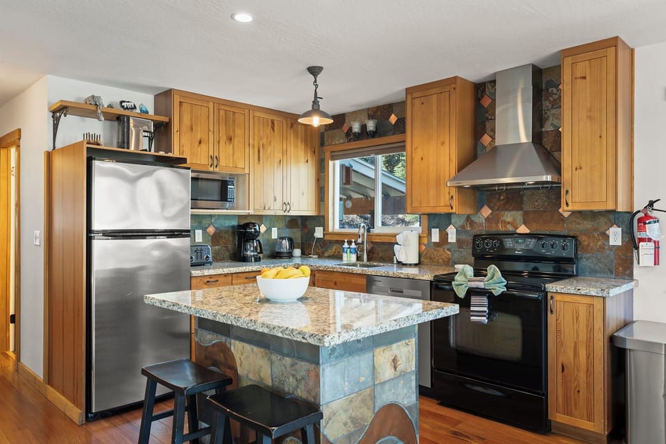 Cook gourmet meals in your fully equipped kitchen featuring granite countertops, stainless steel appliances, and a convenient island for prep work.