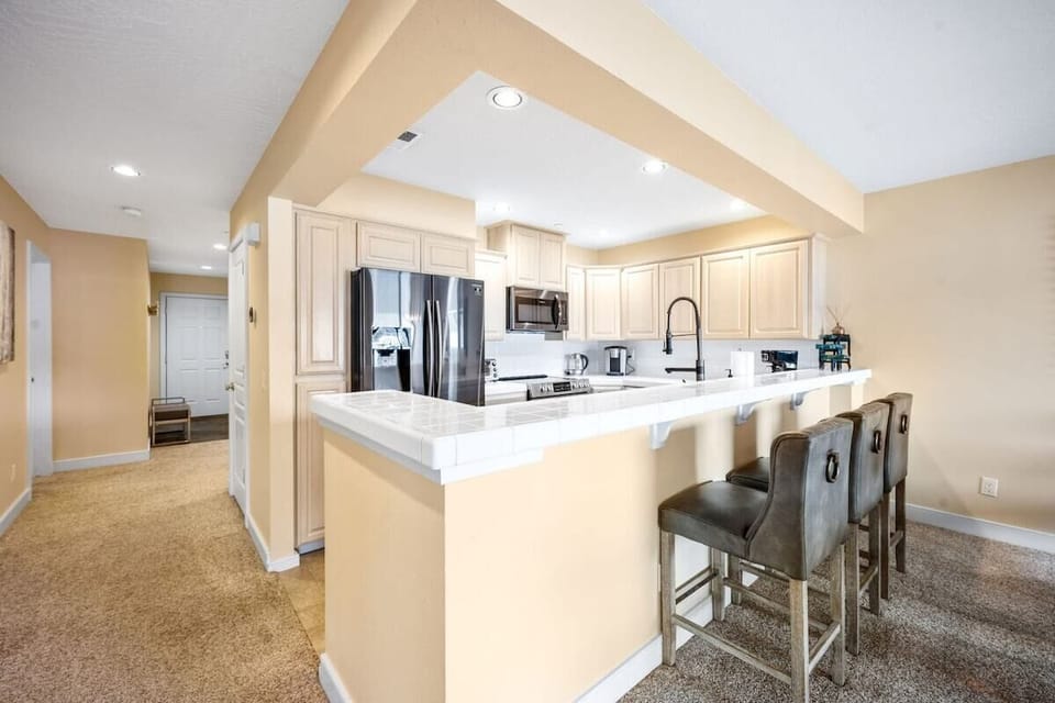 Your spacious kitchen features gleaming countertops, modern appliances, and a breakfast bar perfect for morning coffee or casual meals.