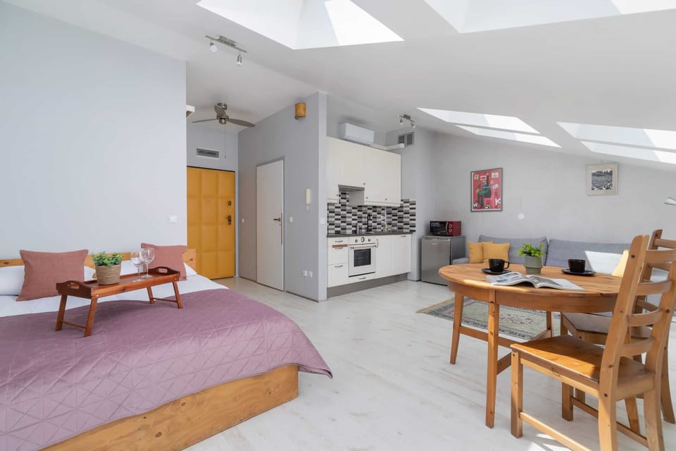 Open-plan studio with a double bed, dining area, and practical layout for comfortable living.

