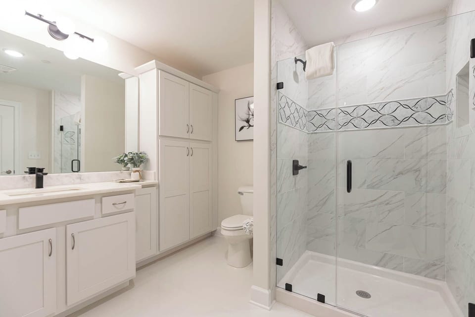 Enjoy a relaxing shower after a day at the beach in this elegant guest bath with stylish accents and fluffy towels