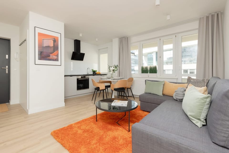 Open-plan living and dining space, featuring vibrant accents and large windows for natural light.

