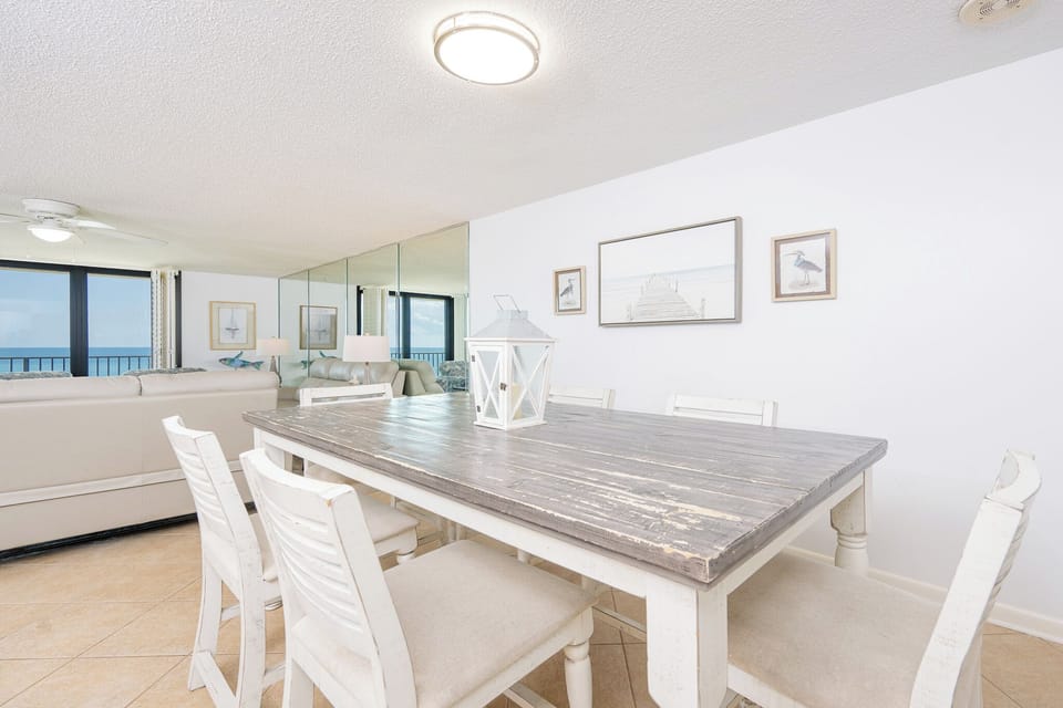 Gather around the rustic dining table, enjoying each other's company while taking in stunning coastal views
