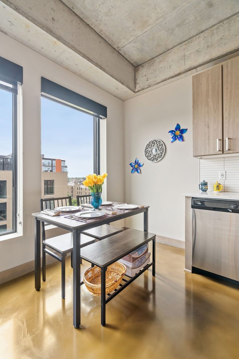 Start your morning with coffee at this bright dining table, where exposed concrete meets warm wood and natural light fills the space.
