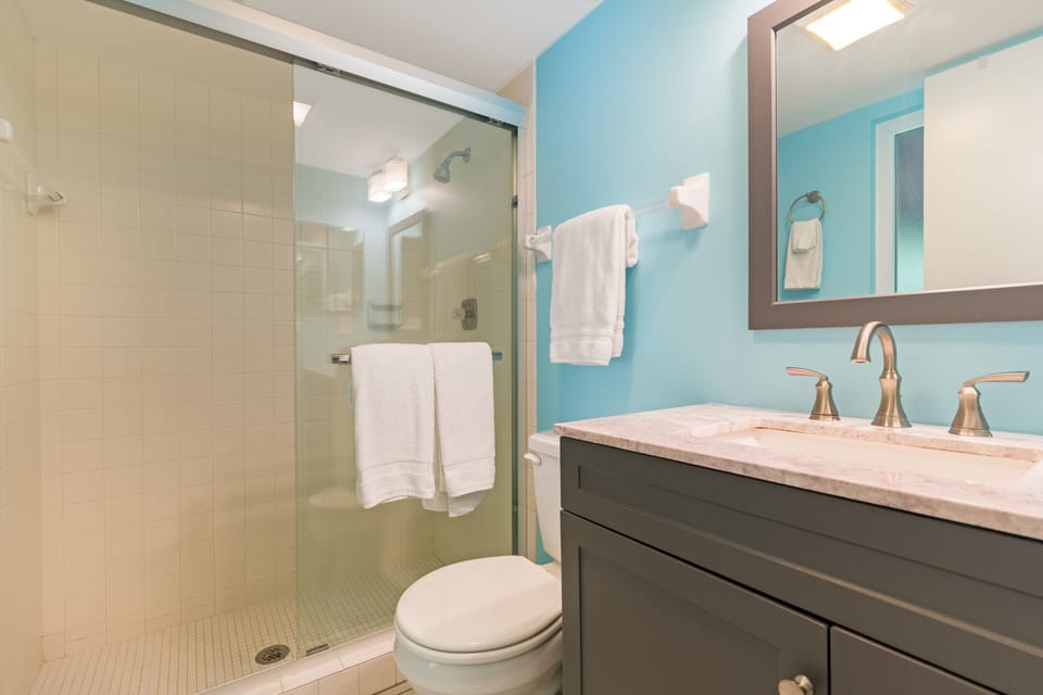 Downstairs full bathroom with glass shower and calming neutral tones for a refreshing retreat.