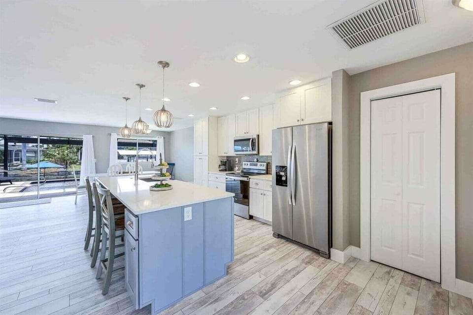 Large Kitchen Island with Stainless Appliances and Fridge with Ice Maker