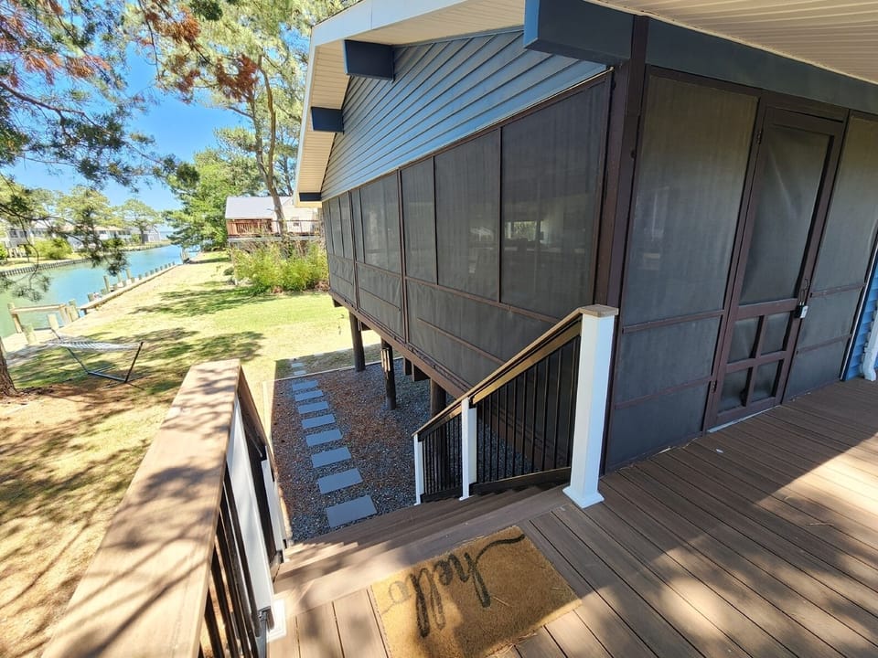 Expansive screened porch with tranquil canal views, perfect for outdoor dining, relaxing, and entertaining.