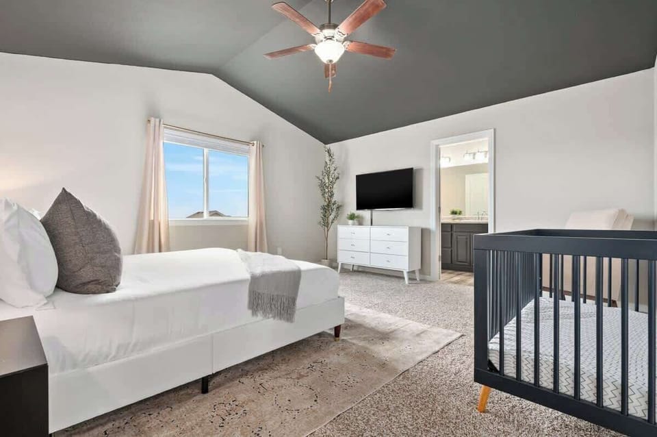 Master bedroom with king bed, crib bed, 50" TV and attached bathroom