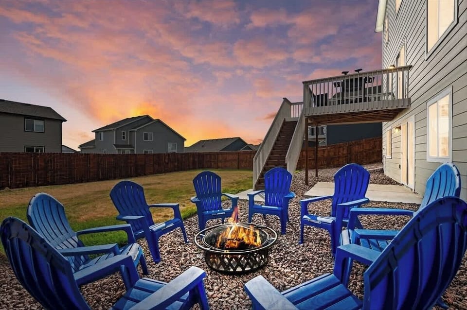 8 chairs around a wood burning campfire pit with marsh mellow sticks
