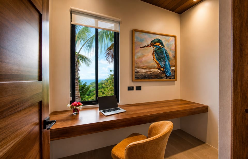 A quiet workspace with a handcrafted wood desk, inspiring ocean and jungle views