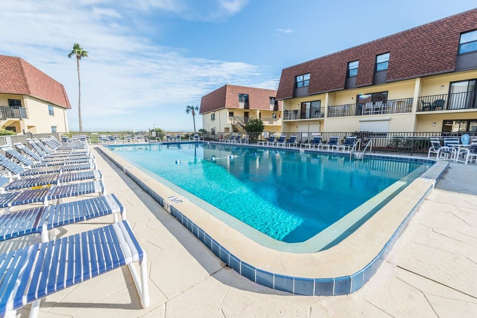 Resort-style pool deck with plenty of lounge chairs for sunbathing and relaxation.