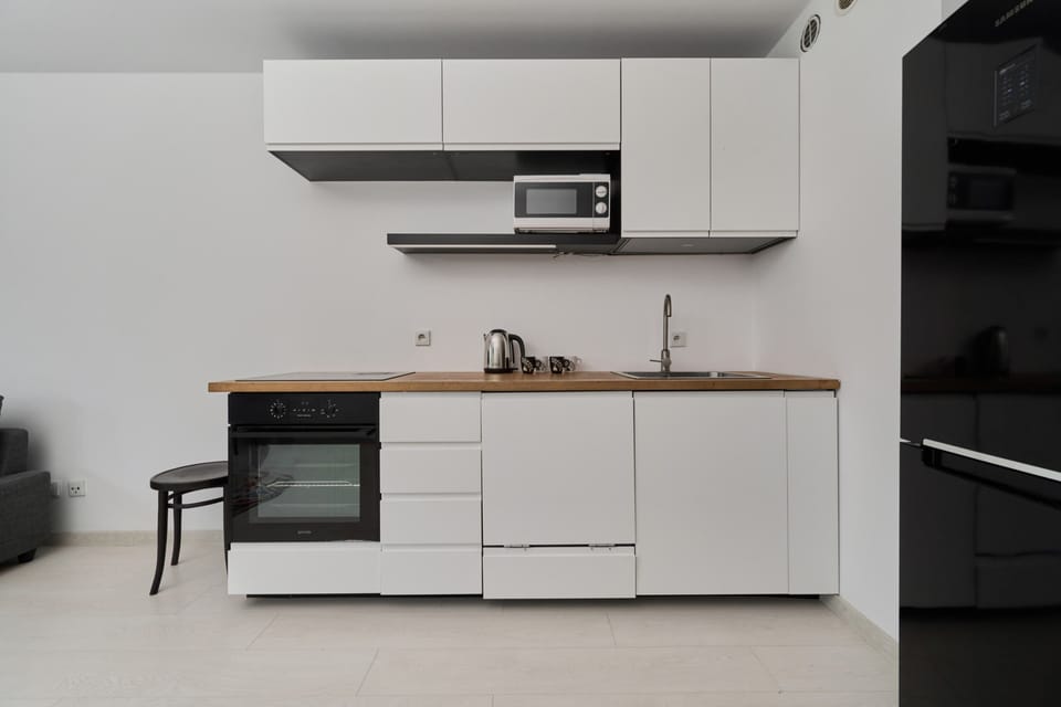 Fully equipped kitchen with modern appliances and a clean white design.

