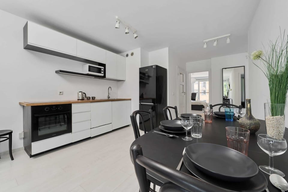 Open dining and living area with stylish furniture and a contemporary kitchen in the background.

