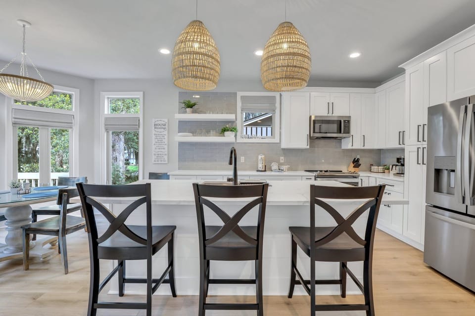 Fully stocked kitchen with stainless steel appliances and 3 barstools for extra seating.