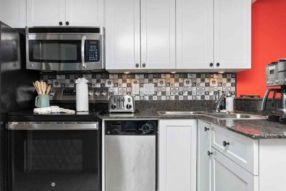 cabinetry, and a granite countertop, opening up to a cozy kitchen area