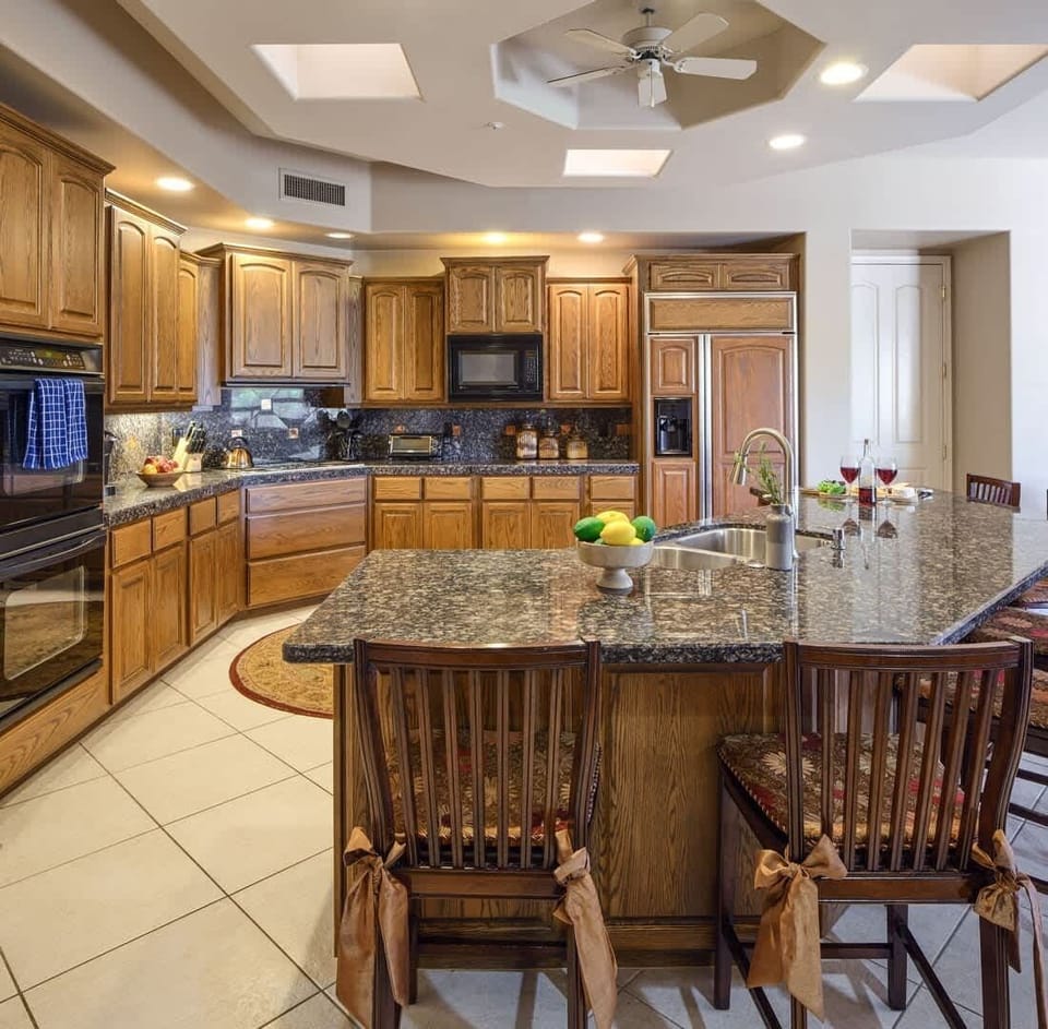 Kitchen fully equipped with high-end appliances, stocked with all culinary essentials. Featuring an oversized island with bar seating