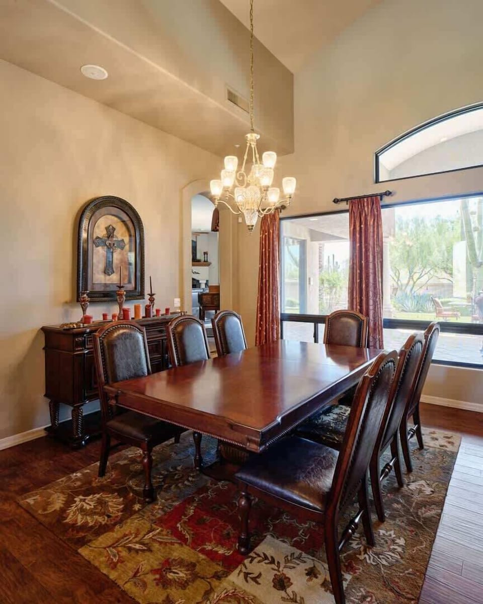 Grand front entrance featuring formal dining area for up to 7 guests, high ceilings, oversized windows providing natural light, and furnishings for lounging.
