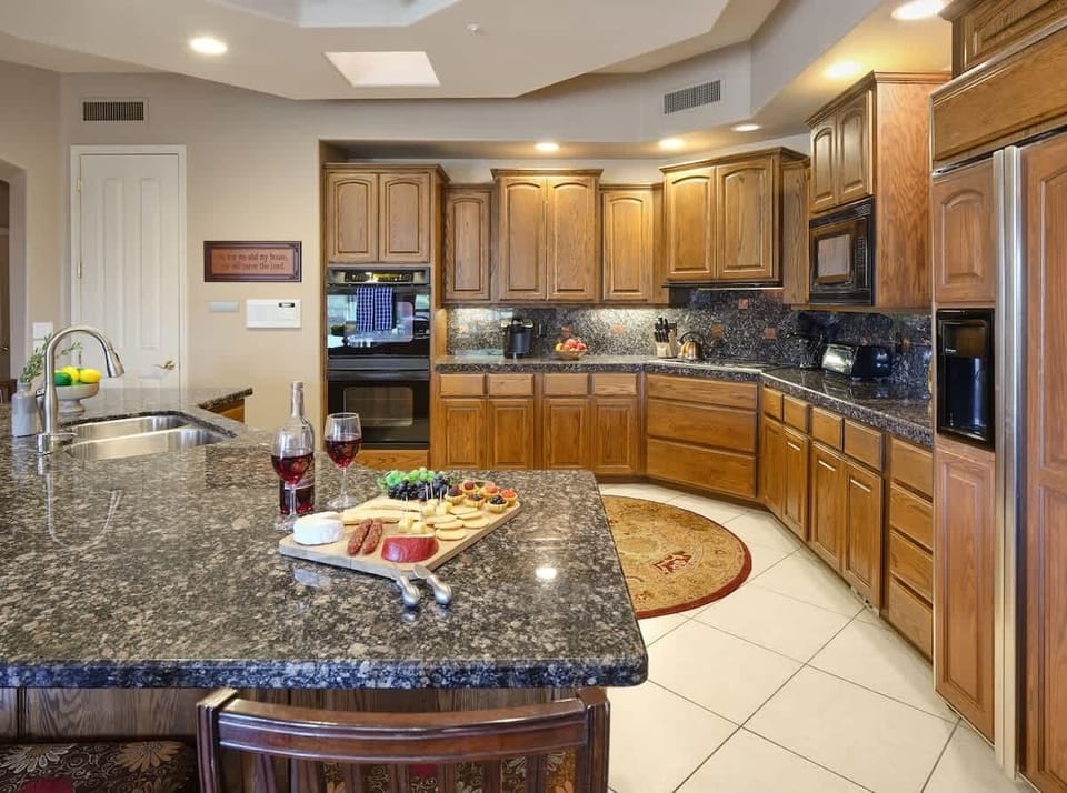 Kitchen fully equipped with high-end appliances, stocked with all culinary essentials. Featuring an oversized island with bar seating