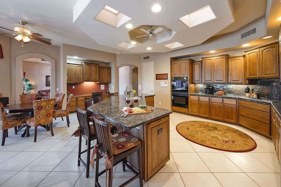 Kitchen fully equipped with high-end appliances, stocked with all culinary essentials. Featuring an oversized island with bar seating, informal dining, and built-in workstation.