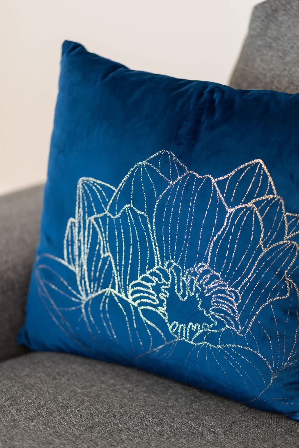 Decorative blue pillow with intricate patterns, adding a pop of color to the sofa.

