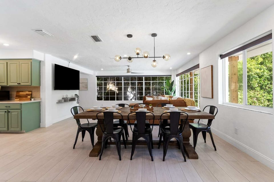 Stylish open-concept design with dining area, green kitchen, and living space