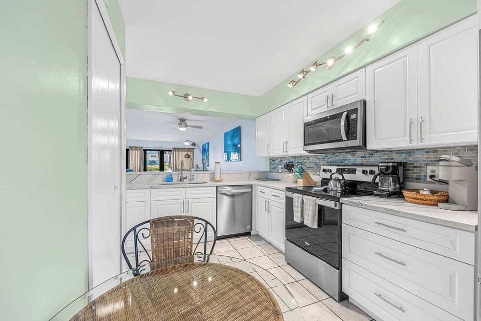 Modern kitchen with stainless steel appliances and a glass dining table.