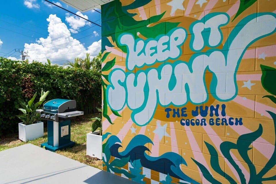 Outdoor grilling area next to a colorful mural at the juni cocoa beach.