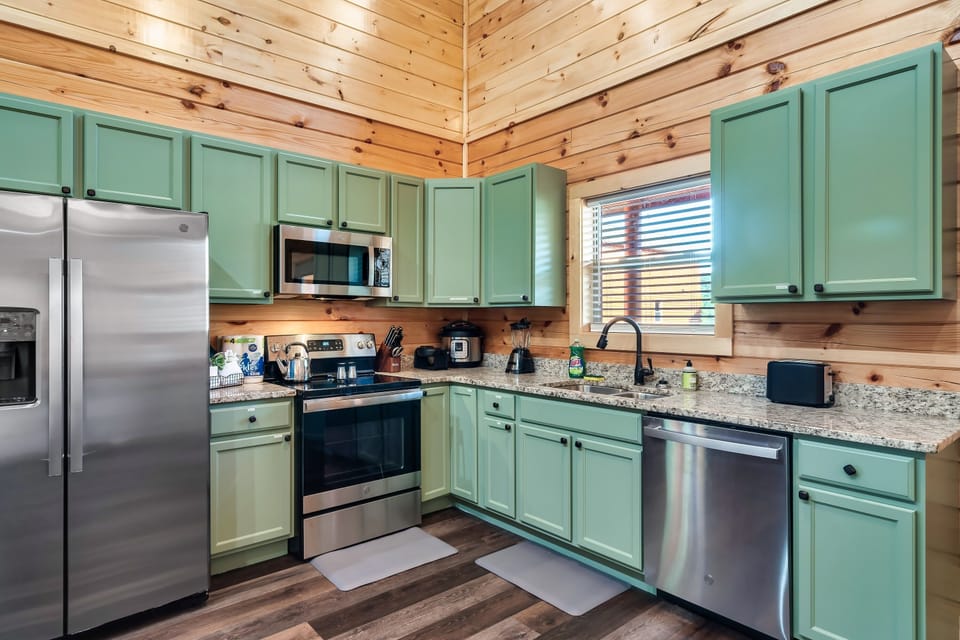Kitchen: Whip up culinary delights in this stylish green kitchen with modern appliances!