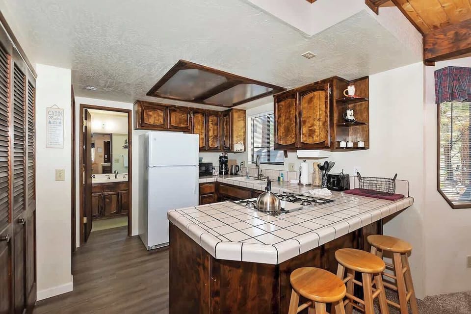 Kitchen equipped with full range with four burners, fridge/freezer, drip coffee maker, microwave, toaster, and standard cooking and dinnerware. 